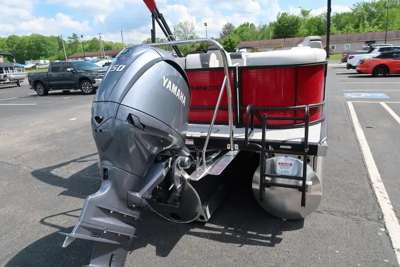 Slide: The Image of 2025 Bennington S Quad Bench 22 SSR pontoon boat with Yamaha outboard motor in parking lot. - 15