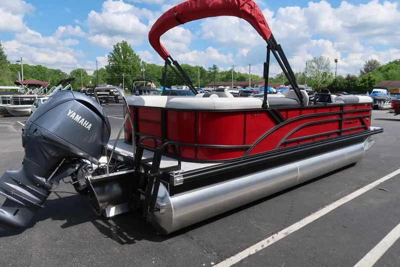 Slide: The Image of 2025 Bennington S Quad Bench 22 SSR pontoon boat with Yamaha engine, parked outdoors. - 16