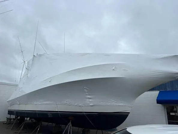 Slide: The Image of 1998 Ocean Yachts 45 Super Sport covered in white tarp, docked outdoors. - 11