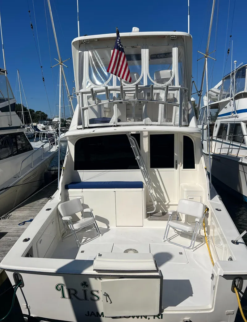 Slide: The Image of 1998 Ocean Yachts 45 Super Sport docked, featuring spacious deck and American flag. - 8