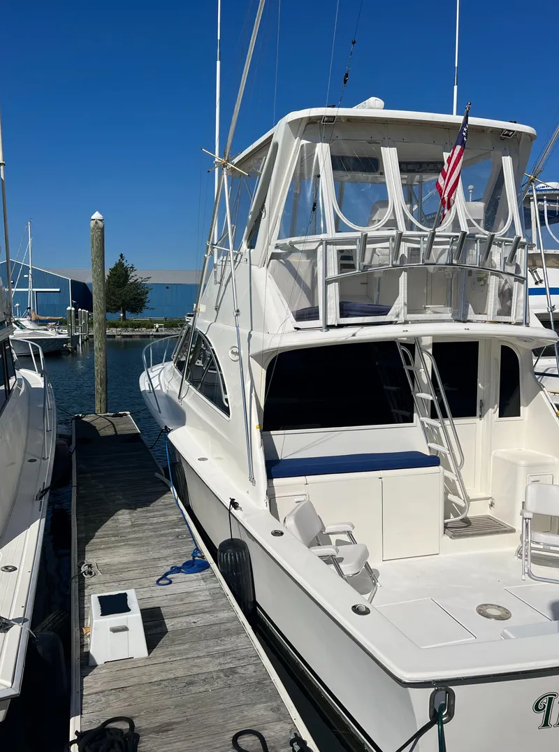 Slide: The Image of 1998 Ocean Yachts 45 Super Sport docked, featuring a flybridge and American flag. - 9