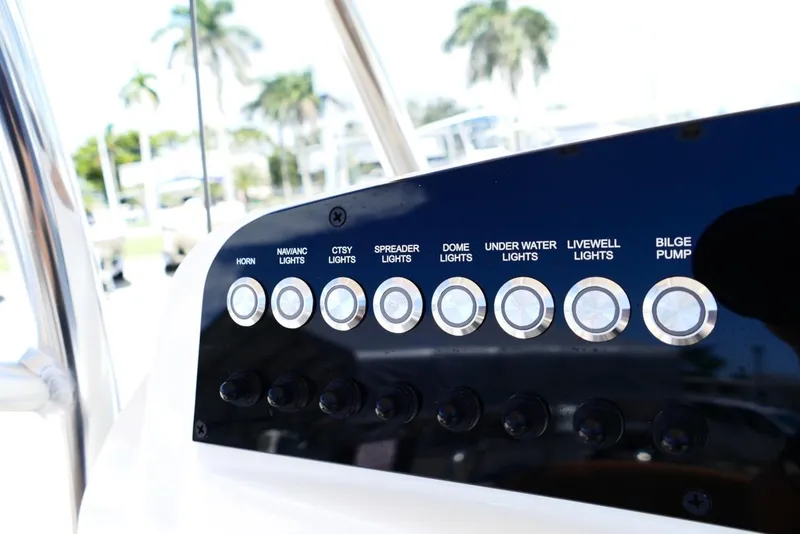 Slide: The Image of Control panel of 2026 Pioneer 222 Islander boat with various light and pump switches. - 17