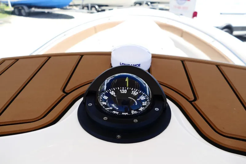 Slide: The Image of Compass on 2026 Pioneer 222 Islander boat deck, featuring wood paneling. - 18