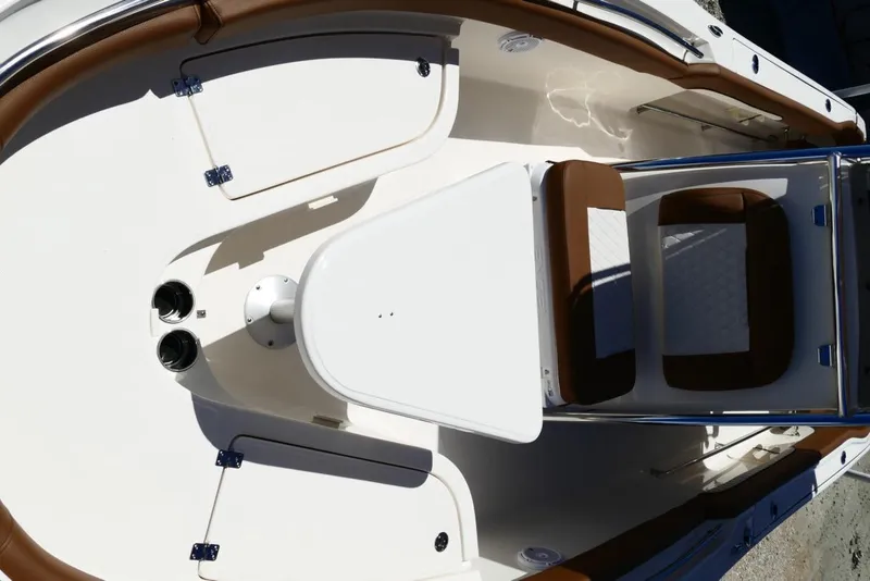 Slide: The Image of 2026 Pioneer 222 Islander boat interior with brown seating and white table. - 29