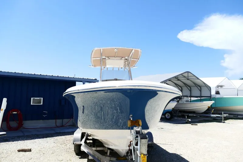 Slide: The Image of 2026 Pioneer 222 Islander boat on trailer, parked outdoors under clear blue sky. - 3