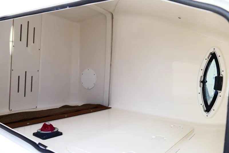 Slide: The Image of Interior cabin of 2026 Pioneer 222 Islander boat with oval window and storage space. - 34