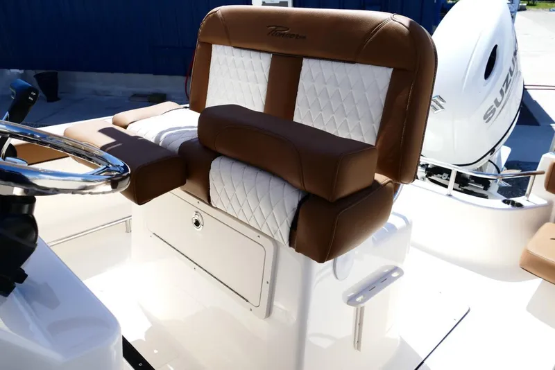 Slide: The Image of 2026 Pioneer 222 Islander boat interior with brown and white seating, Suzuki engine visible. - 36