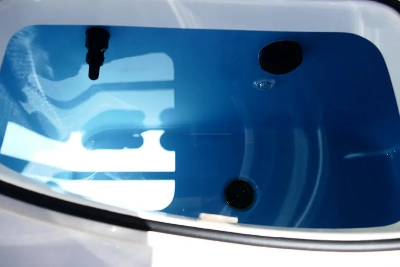 Slide: The Image of Livewell interior of 2026 Pioneer 222 Islander boat, featuring blue water and drain fittings. - 40