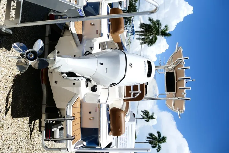 Slide: The Image of 2026 Pioneer 222 Islander boat with outboard motor, parked under clear blue sky. - 7
