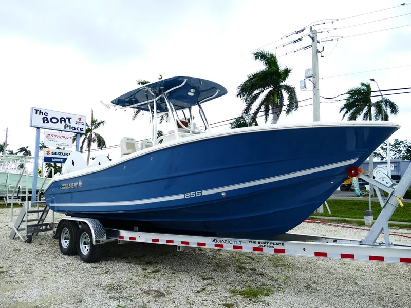 Slide: The Image of 2026 Bulls Bay 255CC boat on trailer at dealership, palm trees in background. - 0