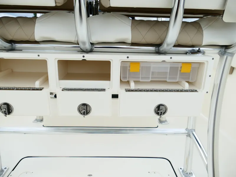 Slide: The Image of 2026 Bulls Bay 255CC boat storage compartments with tackle box and cushioned seating. - 10