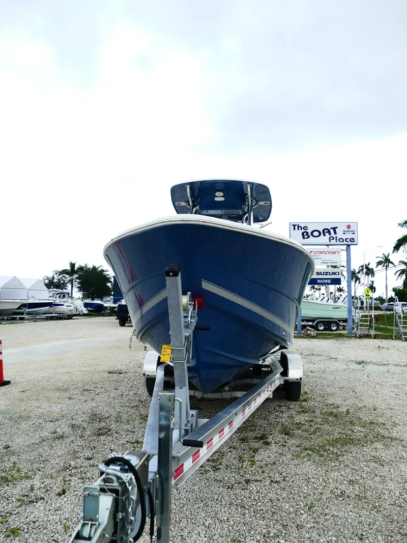 Slide: The Image of 2026 Bulls Bay 255CC boat on trailer at dealership, cloudy sky background. - 2