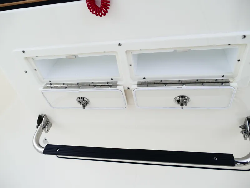 Slide: The Image of 2026 Bulls Bay 255CC boat storage compartments with secure latches and stainless steel handle. - 28