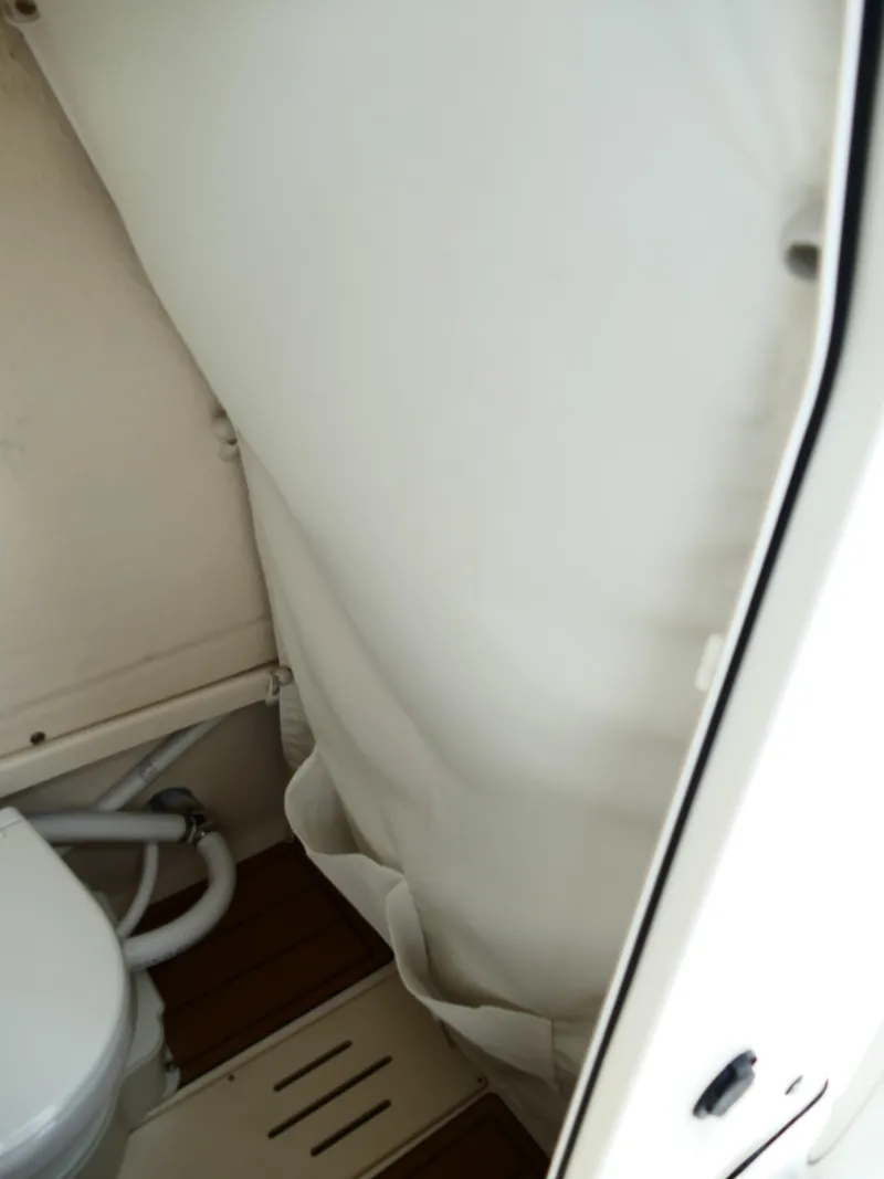 Slide: The Image of 2026 Bulls Bay 255CC boat interior with toilet and white curtain. - 35