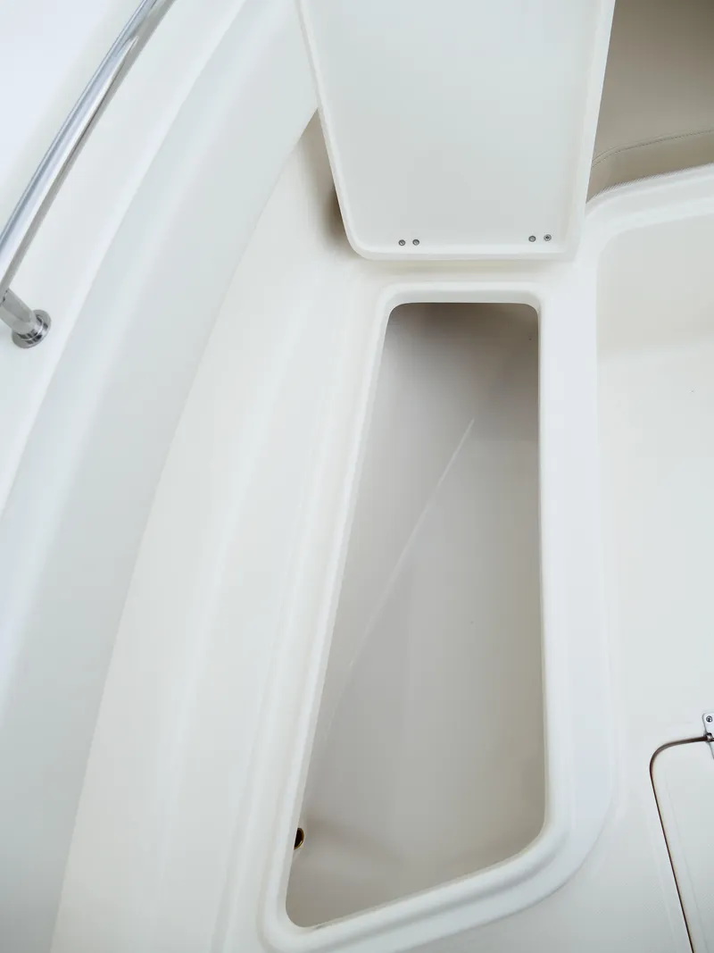 Slide: The Image of 2026 Bulls Bay 255CC boat storage compartment, open lid, white interior. - 41