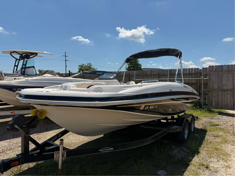 Slide: The Image of 2012 Tahoe 195 boat on trailer under clear blue sky. - 1