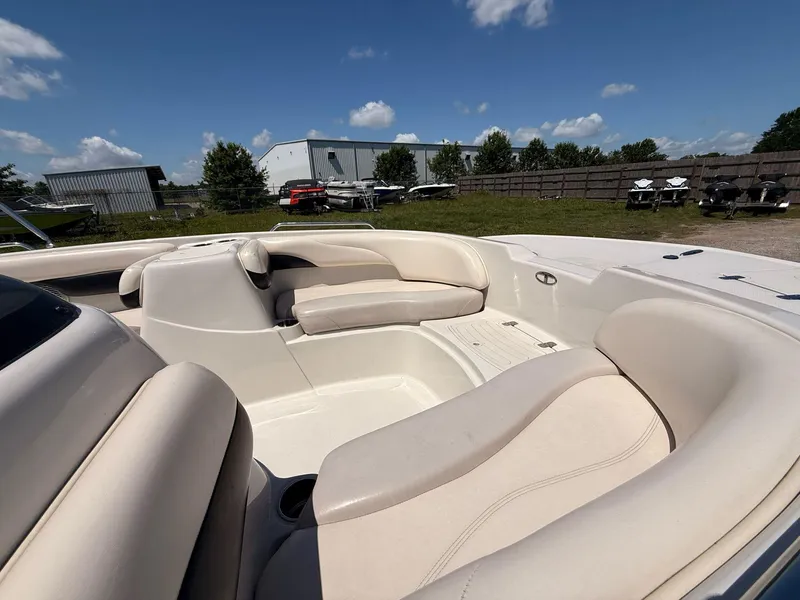 Slide: The Image of 2012 Tahoe 195 boat interior with beige seating, parked outdoors under a clear blue sky. - 8