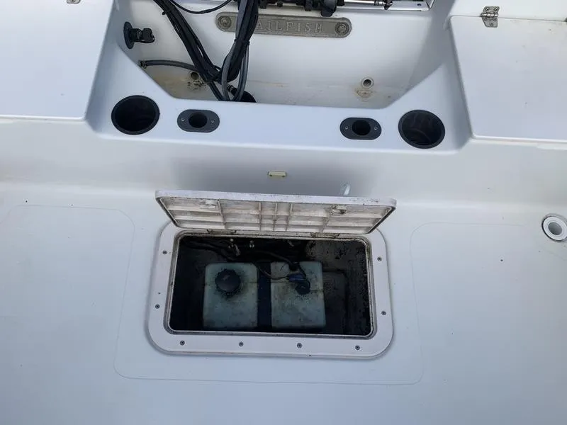 Slide: The Image of 2005 Sailfish 198 DC boat storage compartment with open hatch and visible wiring. - 12
