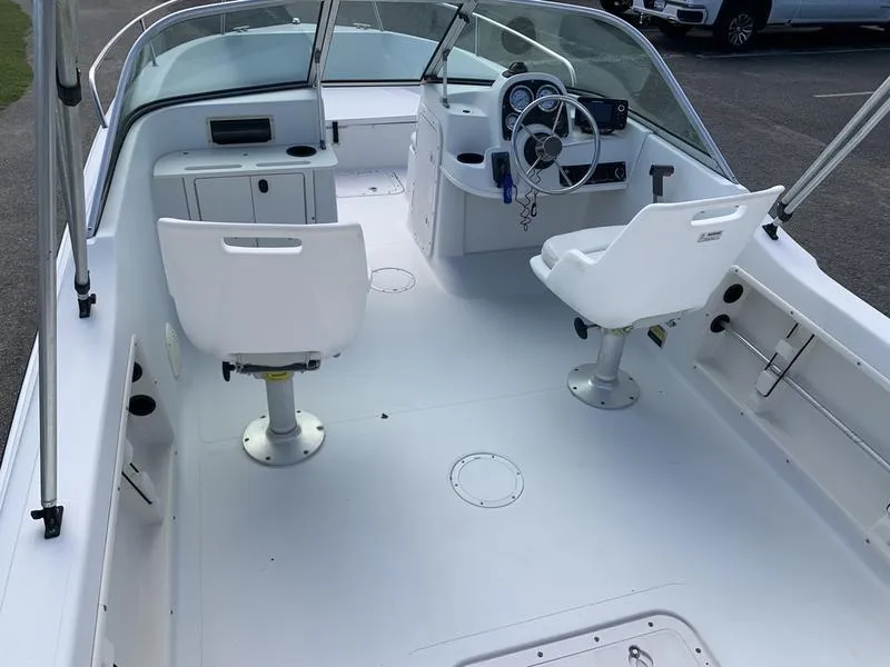Slide: The Image of 2005 Sailfish 198 DC boat interior with dual white seats and steering console. - 14