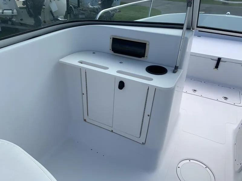 Slide: The Image of 2005 Sailfish 198 DC boat interior with storage compartment and cup holder. - 16