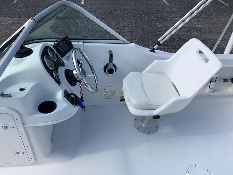 Slide: The Image of 2005 Sailfish 198 DC boat cockpit with steering wheel and white captain's chair. - 18