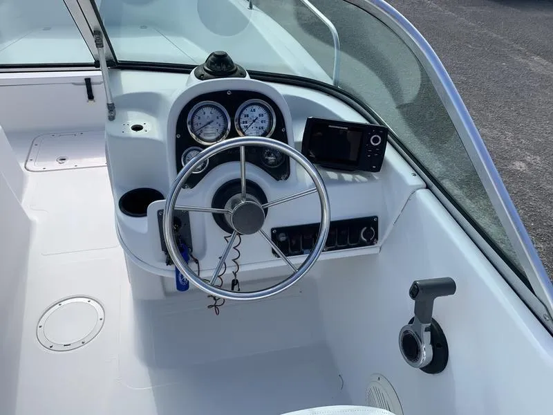 Slide: The Image of 2005 Sailfish 198 DC boat cockpit with steering wheel, gauges, and navigation system. - 19