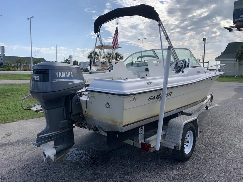 Slide: The Image of 2005 Sailfish 198 DC boat on trailer with Yamaha 115 outboard motor, parked outdoors. - 4