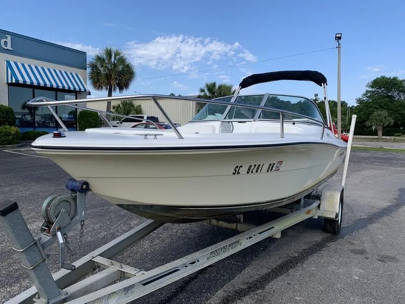 Slide: The Image of 2005 Sailfish 198 DC boat on trailer in parking lot, clear sky background. - 8