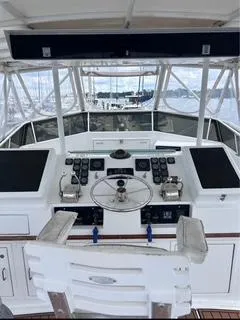 Slide: The Image of 1986 Egg Harbor 60 Sportfisherman helm with controls and steering wheel, marina view. - 16