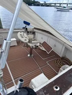 Slide: The Image of 1986 Egg Harbor 60 Sportfisherman boat deck with fishing chair and equipment, docked by the water. - 5