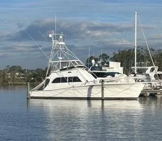The Image of 1986 Egg Harbor 60 Sportfisherman yacht docked on calm water under cloudy sky. - 0