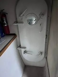 Slide: The Image of 1986 Egg Harbor 60 Sportfisherman interior with a secure, white hatch door and fire extinguisher. - 14