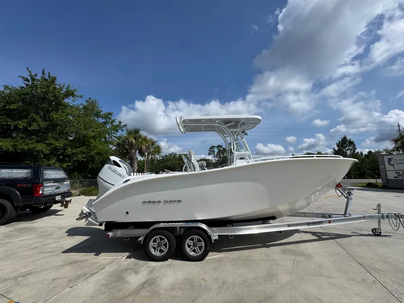 Slide: The Image of 2025 Cape Horn 22 OS boat on trailer, parked outdoors under a partly cloudy sky. - 10