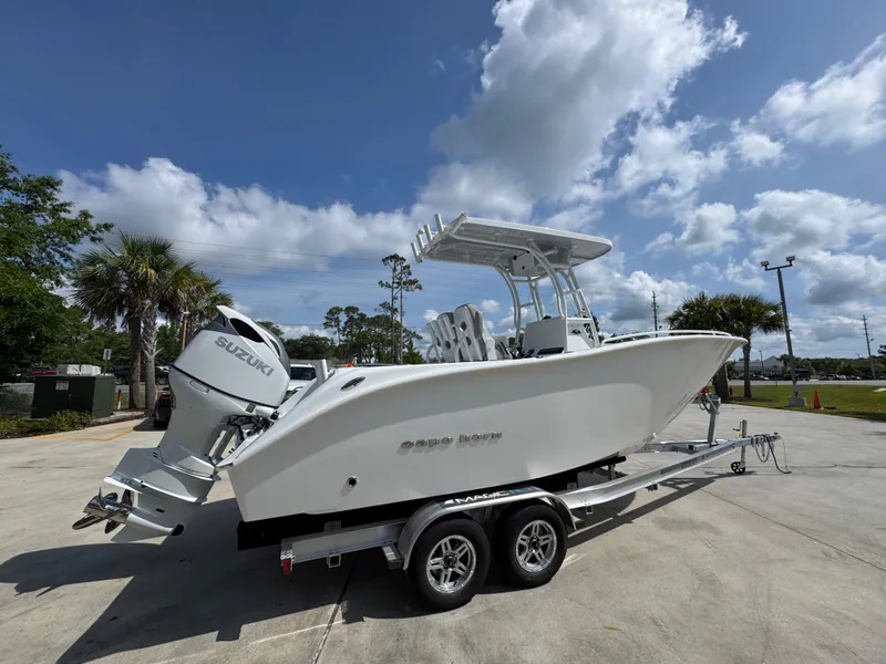 Slide: The Image of 2025 Cape Horn 22 OS boat on trailer under a partly cloudy sky. - 11
