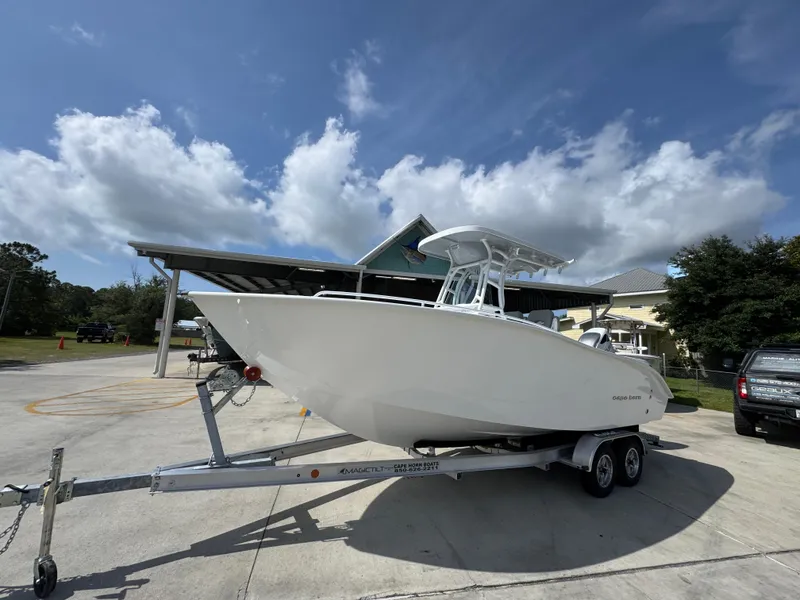 Slide: The Image of 2025 Cape Horn 22 OS boat on trailer under a partly cloudy sky. - 2