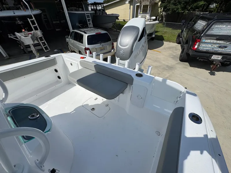 Slide: The Image of 2025 Cape Horn 22 OS boat interior with seating and motor, parked in a driveway. - 39