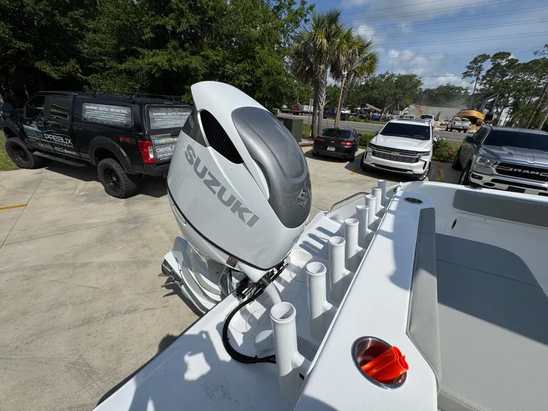 Slide: The Image of 2025 Cape Horn 22 OS boat with Suzuki outboard motor in a parking lot. - 42