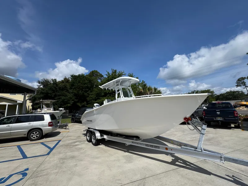 Slide: The Image of 2025 Cape Horn 22 OS boat on trailer in parking lot under blue sky. - 8