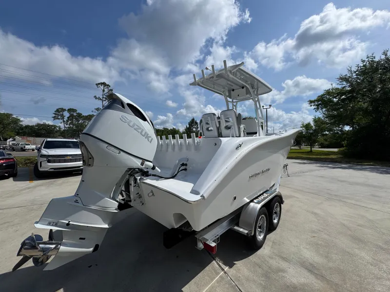 Slide: The Image of 2025 Cape Horn 22 OS boat on trailer, parked outdoors under a partly cloudy sky. - 12