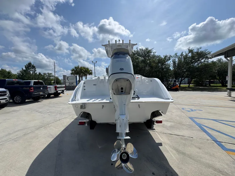Slide: The Image of 2025 Cape Horn 22 OS boat, rear view, parked outdoors under a partly cloudy sky. - 14