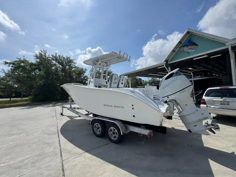 Slide: The Image of 2025 Cape Horn 22 OS boat on trailer, parked outside a garage under a clear sky. - 17
