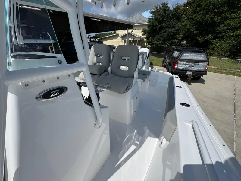 Slide: The Image of 2025 Cape Horn 22 OS boat interior with seating and dashboard, parked outdoors. - 27
