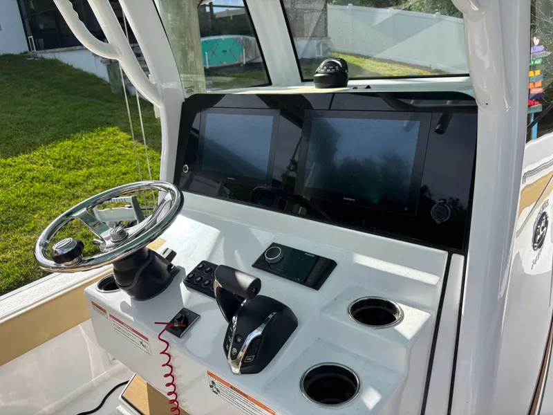Slide: The Image of 2024 Sportsman Masters 247OE Bay Boat dashboard with dual screens and steering wheel. - 3