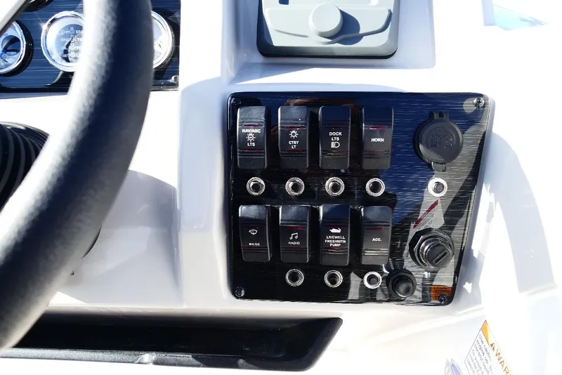 Slide: The Image of Control panel of 2026 Starcraft SVX 211 OB boat with various switches and gauges. - 18