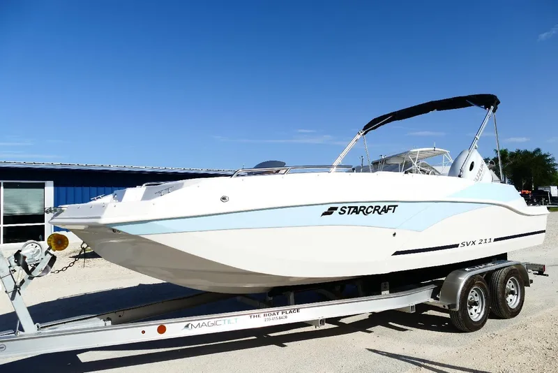 Slide: The Image of 2026 Starcraft SVX 211 OB boat on trailer under clear blue sky. - 2