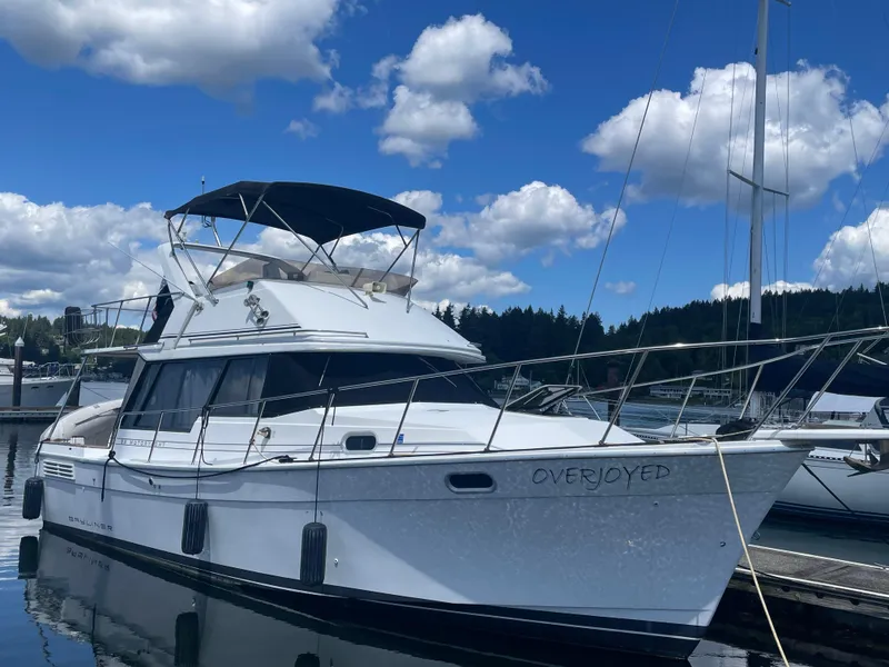 The Image of 1993 Bayliner 3288 yacht docked under a blue sky with clouds. - 0