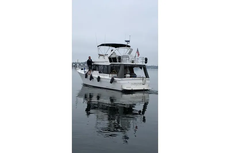 Slide: The Image of Bayliner 3288 Motoryacht 1993 cruising on calm waters with American flag. - 13