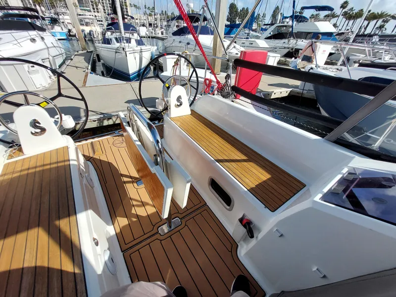 Slide: The Image of Beneteau Oceanis 30.1 sailboat cockpit with dual steering wheels, docked at marina, 2020 model. - 16