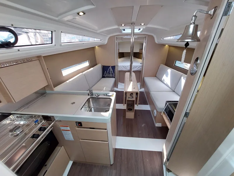 Slide: The Image of Interior of 2020 Beneteau Oceanis 30.1 yacht, featuring modern kitchen and cozy seating area. - 26