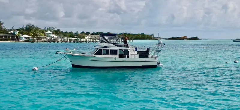 Slide: The Image of 1982 Albin 43 boat anchored in clear turquoise waters near a coastal area. - 1